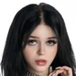 Nevaaadaa standing outdoors with long black hair wearing trendy black, white, and pink clothing.